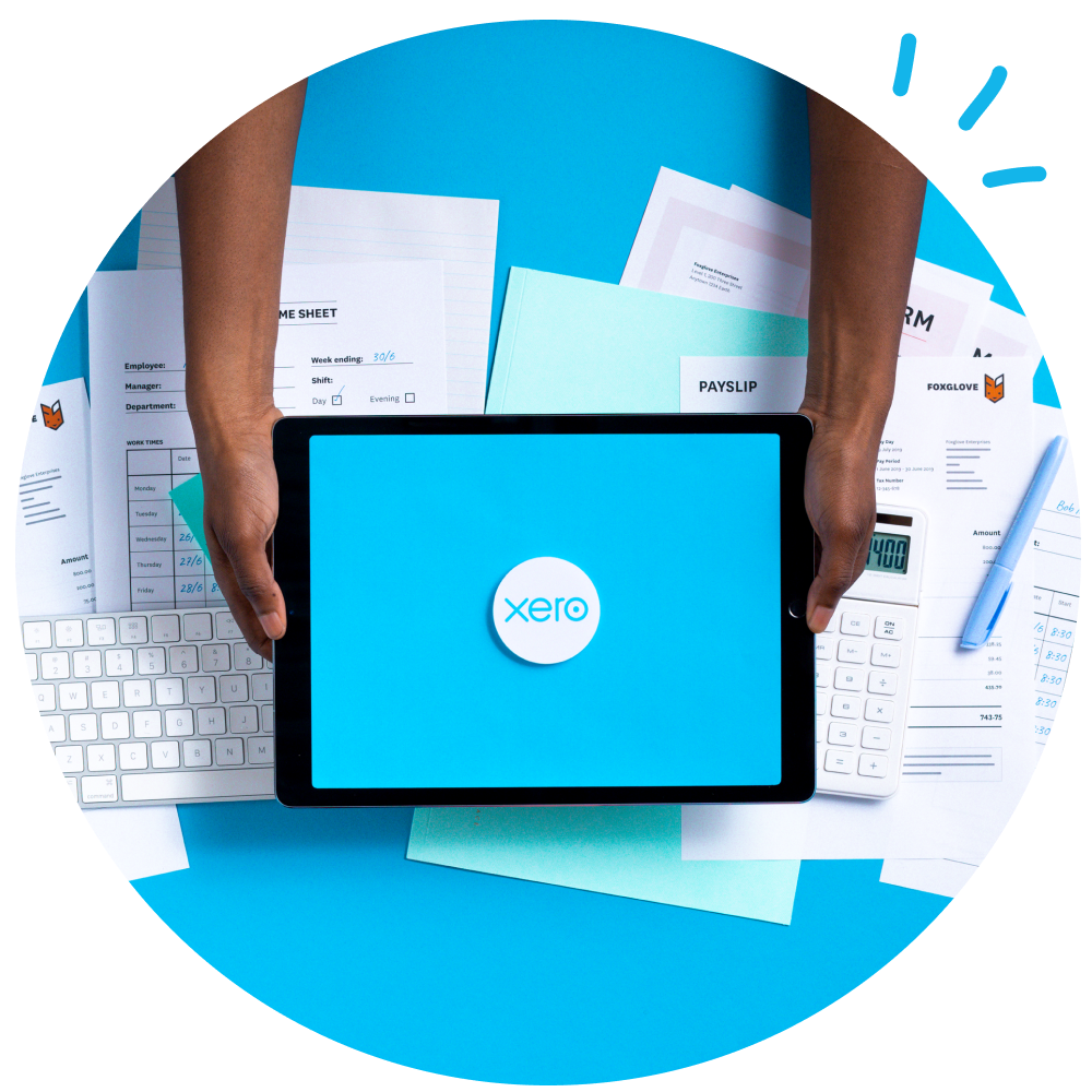 two hands holding IPad with Xero logo on screen and paperwork in the background